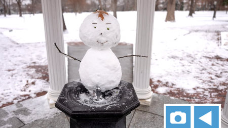 Snowman behind the fountain of the Old Well on the campus of UNC-Chapel Hill.